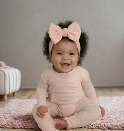 Baby wearing Stretchaboo Hint of Pink Bamboo Baby Grow with matching bow
